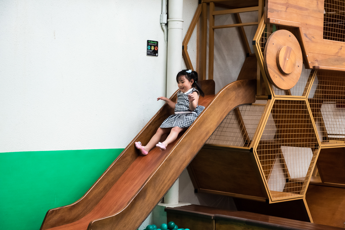 menina descendo o escorregador de madeira