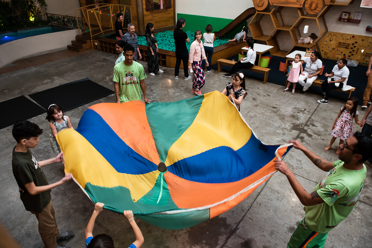 crianças esticando o lençol colorido
