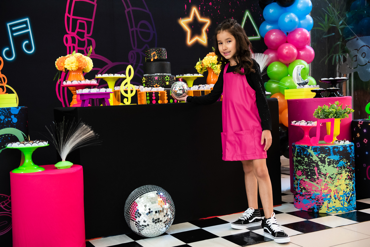 menina de vestido rosa curtindo a sua mesa de parabéns