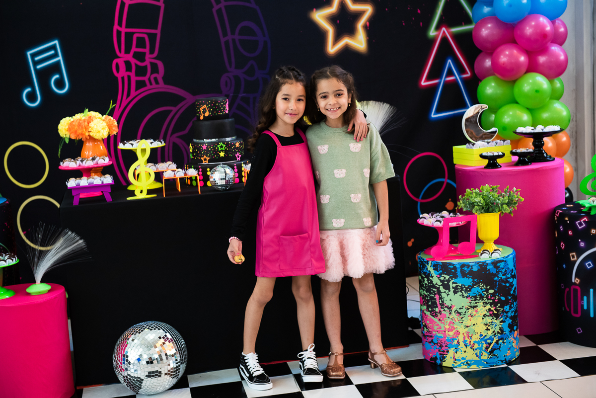 duas meninas se abraçando na mesa de parabéns