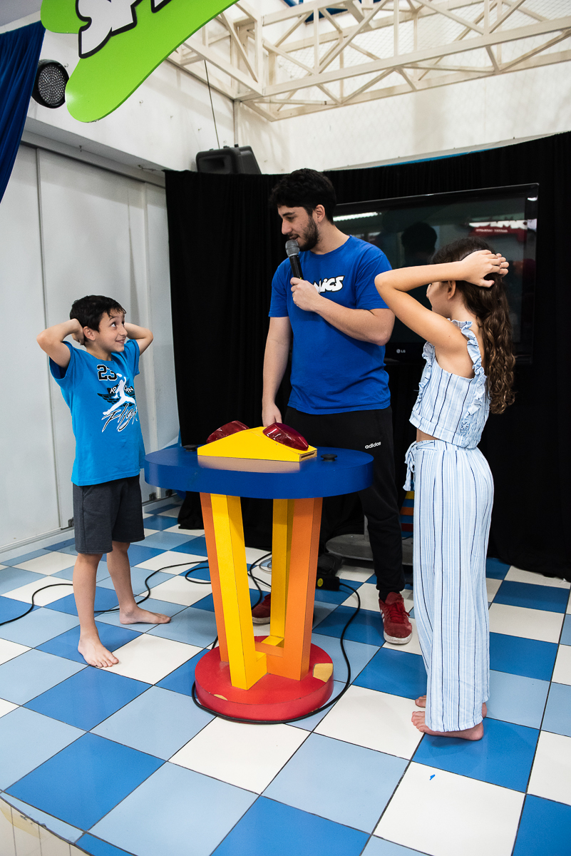 o monitor explicando como funciona a brincadeira de quem aperta primeiro o botão