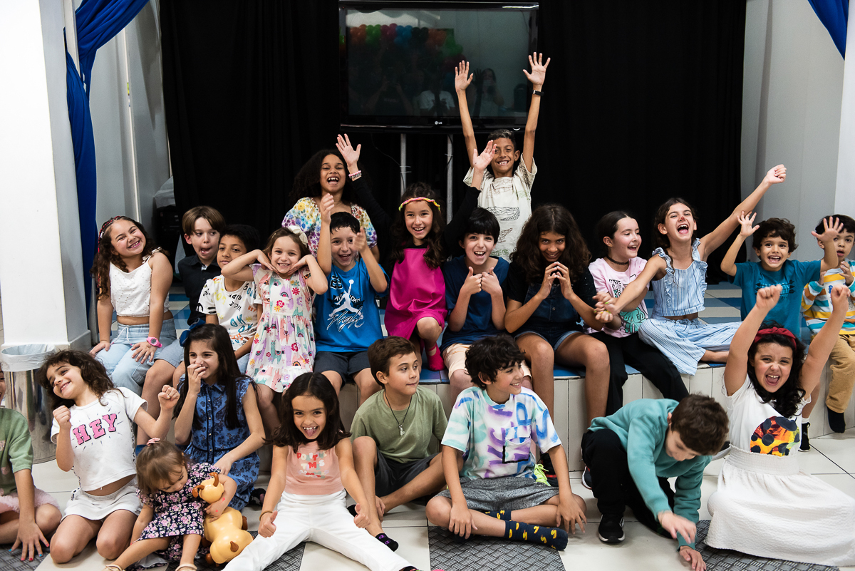 crianças levantando os braços para as fotos