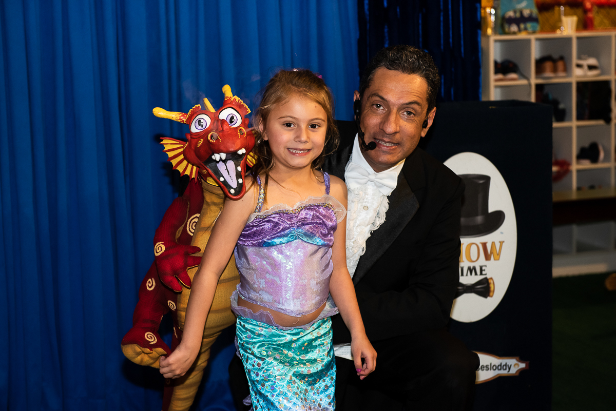 Dragão, a aniversariante Pequena Sereia e o Mágico Ulisses Loddy sorrindo para a foto