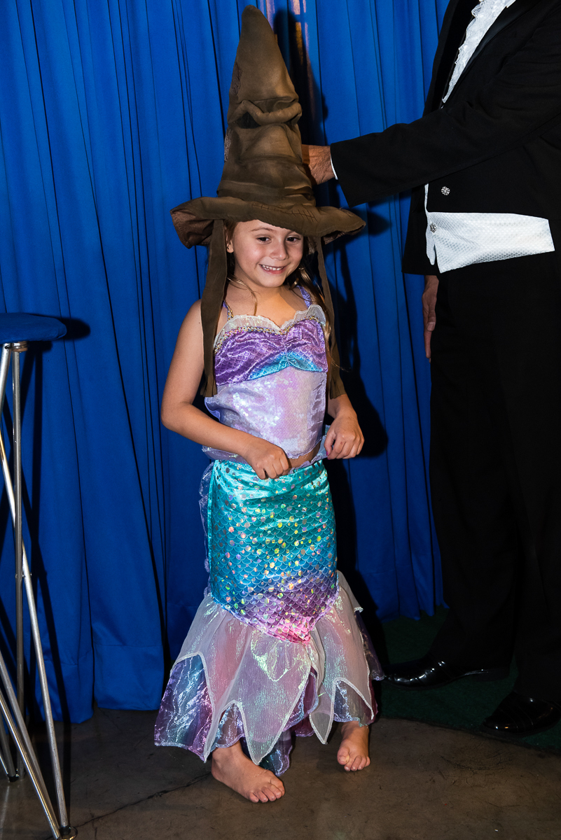 A aniversariante vestida de Pequena Sereia se preparando para o próximo truque de mágica