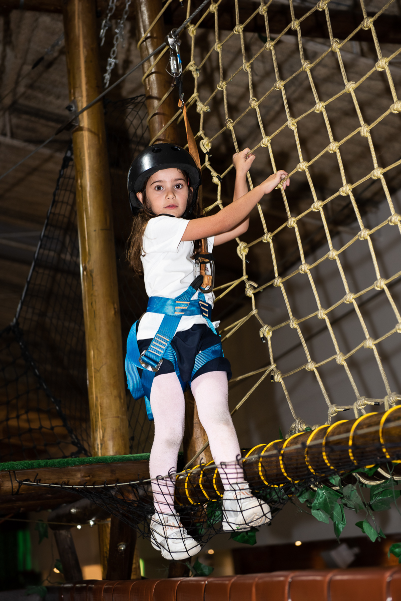 menina escalando na rede do brinquedão