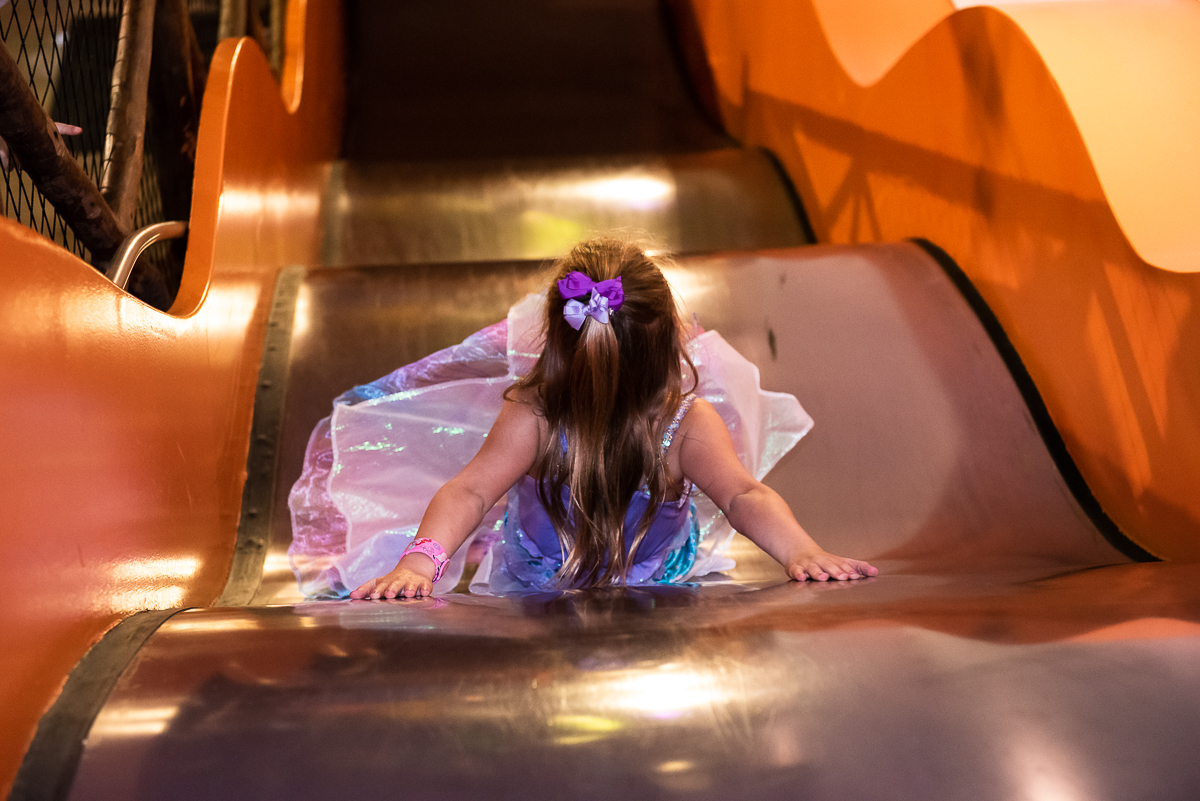 a aniversariante aproveitando o tobogã laranja do buffet Espaço Puzzle