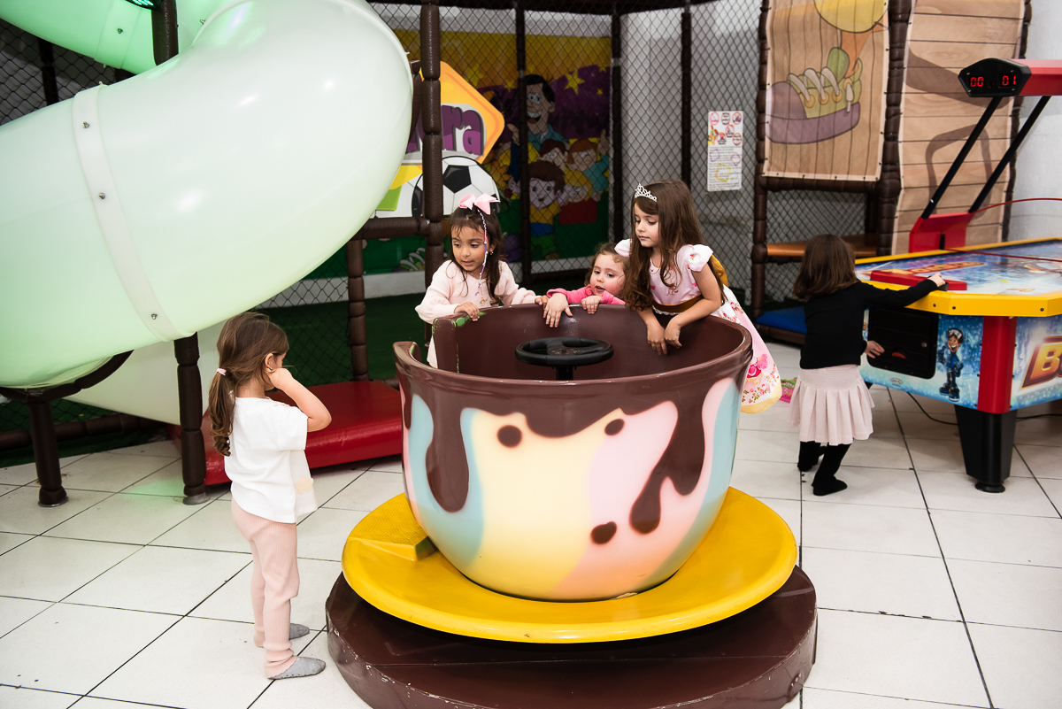 crianças se divertindo no brinquedo xícara