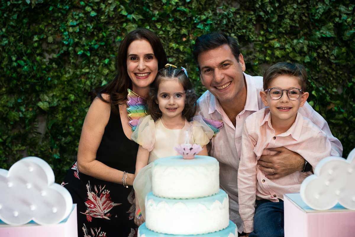 família feliz posando para a foto na mesa do bolo