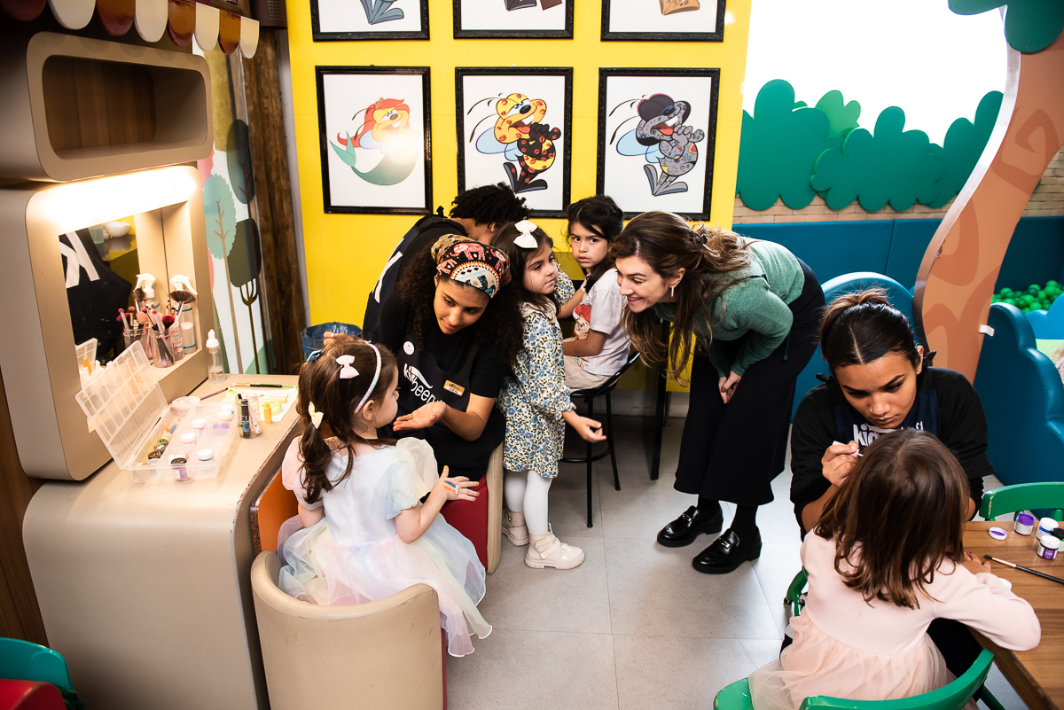 várias crianças esperando para fazer pinturas