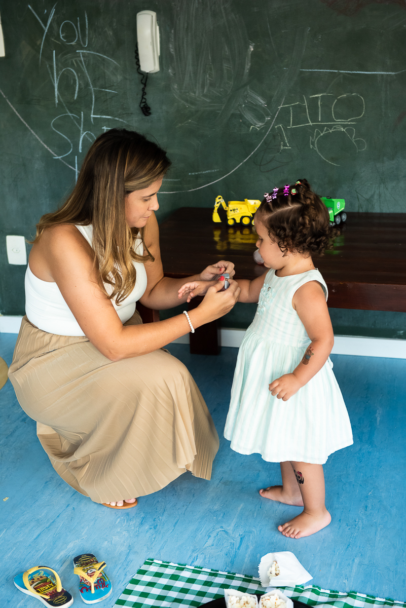mamãe colocando pulseirinha na filha