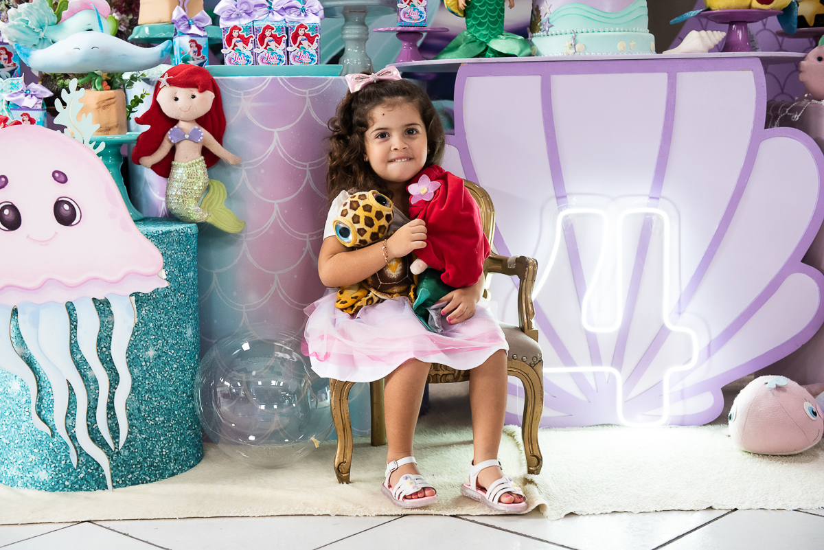 aniversariante sentada na cadeirinha da Ariel