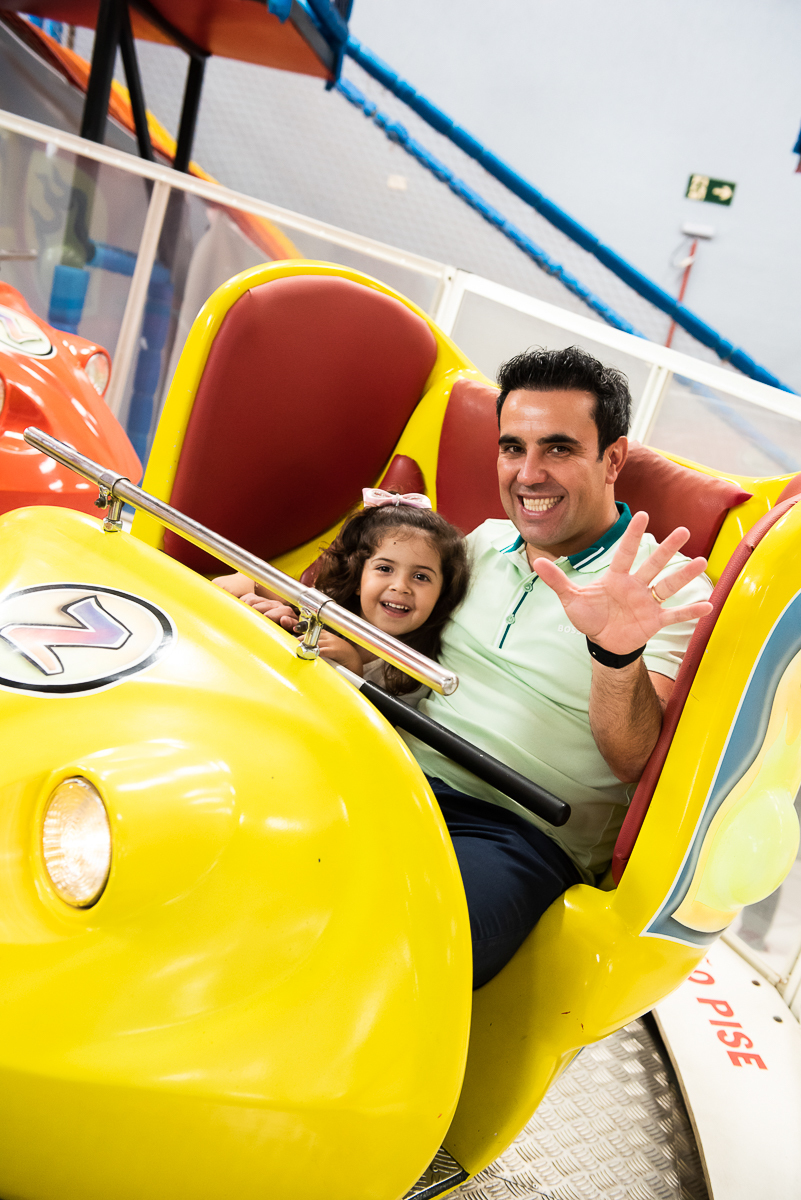 menina com o papai no carrinho amarelo