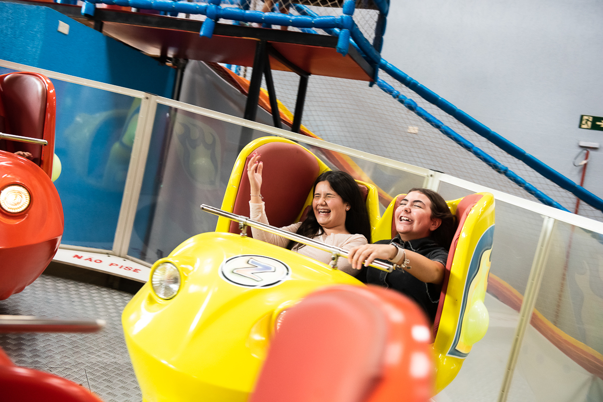 duas meninas se divertindo no carrinho amarelo