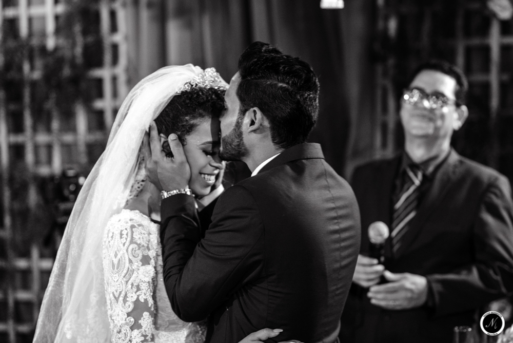 Noivo beija testa da noiva durante a cerimonia de casamento realizado ao ar livre em aparecida de goiania