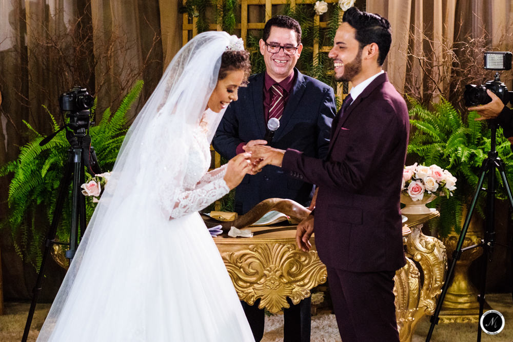 Noiva sorrindo durante a troca de alianças 