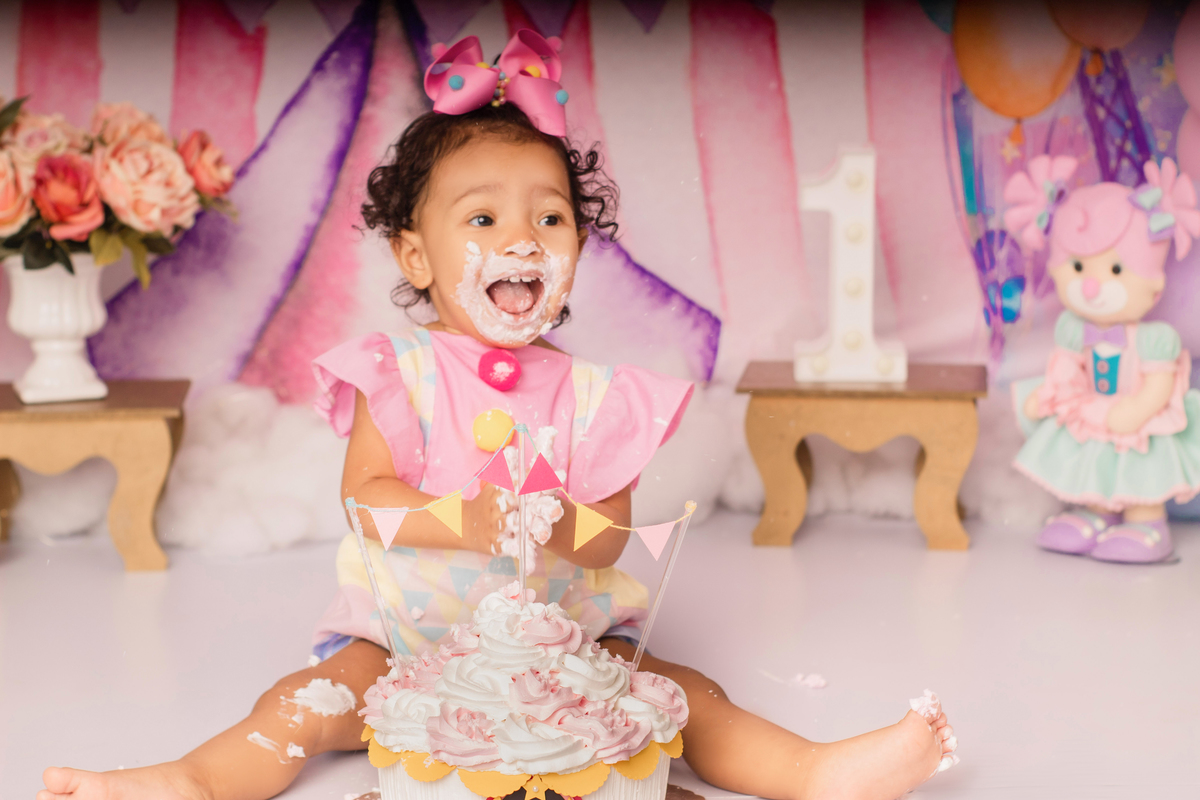 Foto do bebê com o bolo baguçando o bolo