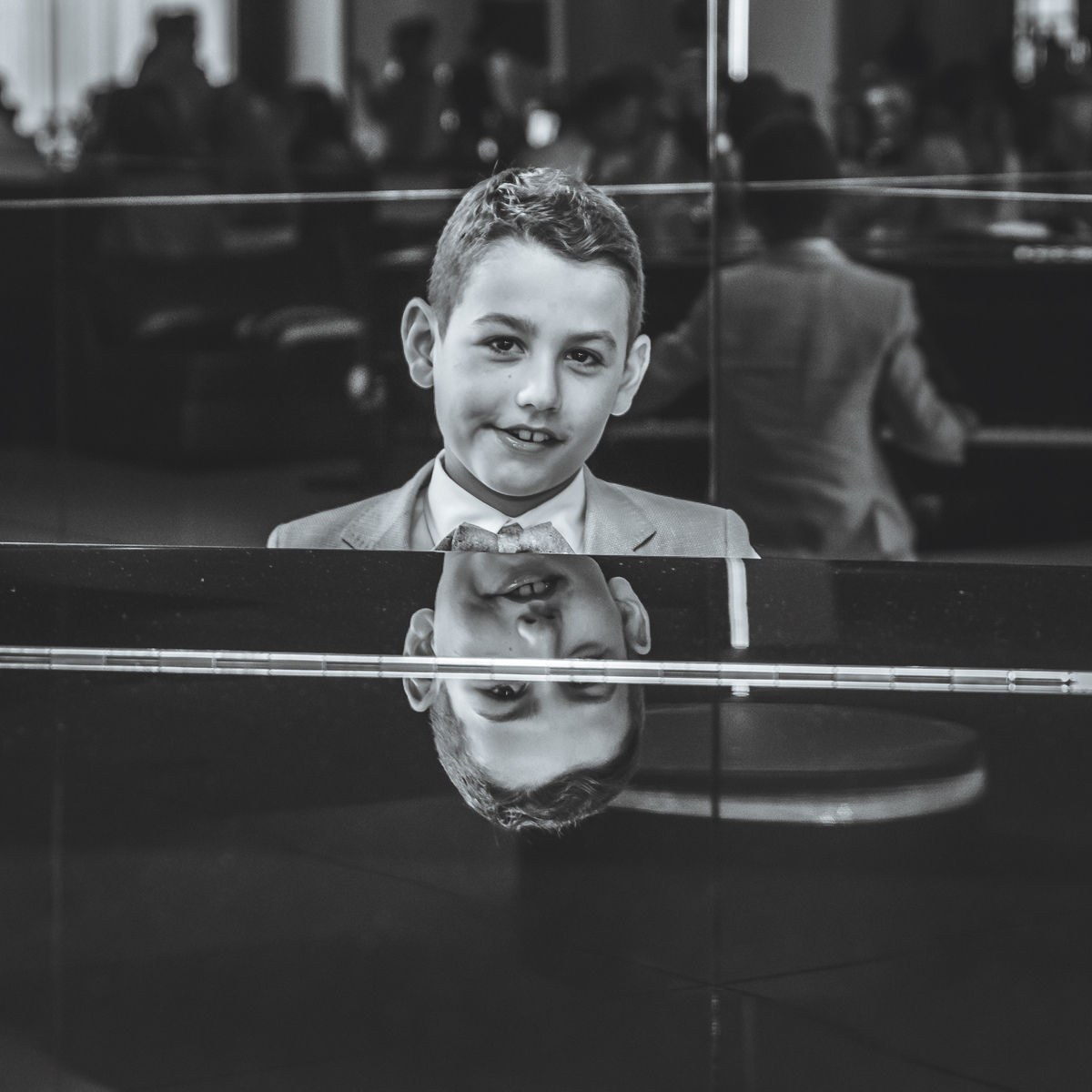 Comunhão menino de fato ao piano preto e branco