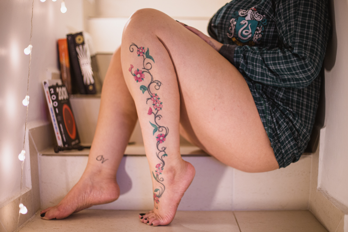 Detalhe livros e luzes no Ensaio feminino sensual em casa com mulher tatuada, Clau e fotografa Dani Ortiz.