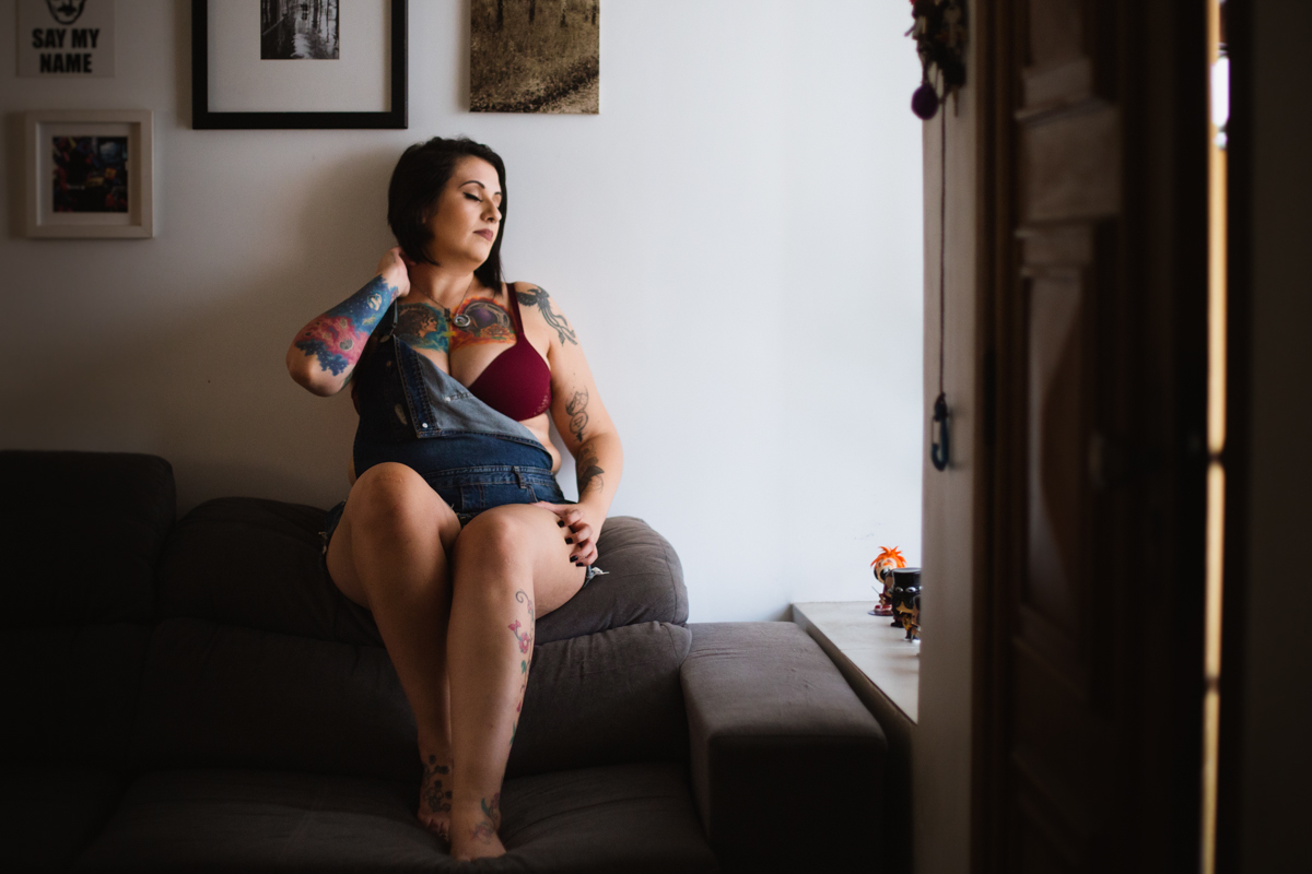 De lingerie vermelha no Ensaio feminino sensual em casa com mulher tatuada, Clau e fotografa Dani Ortiz.