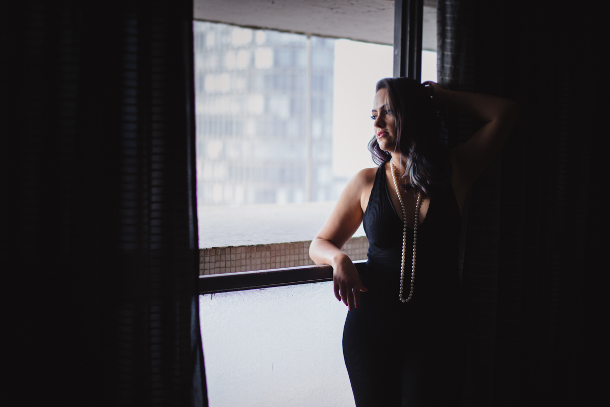Retrato na janela no Ensaio feminino sensual no Copan pelo Airbnb, com maquiadora Flavia Molina e fotografa Dani Ortiz.