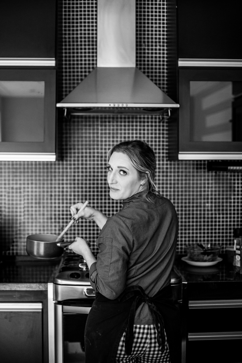 Ensaio de mulher empreendedora na gastronomia e confeitaria Mari Schiesari cozinhando no fogão no Bairro Saúde em São Paulo com Dani Ortiz
