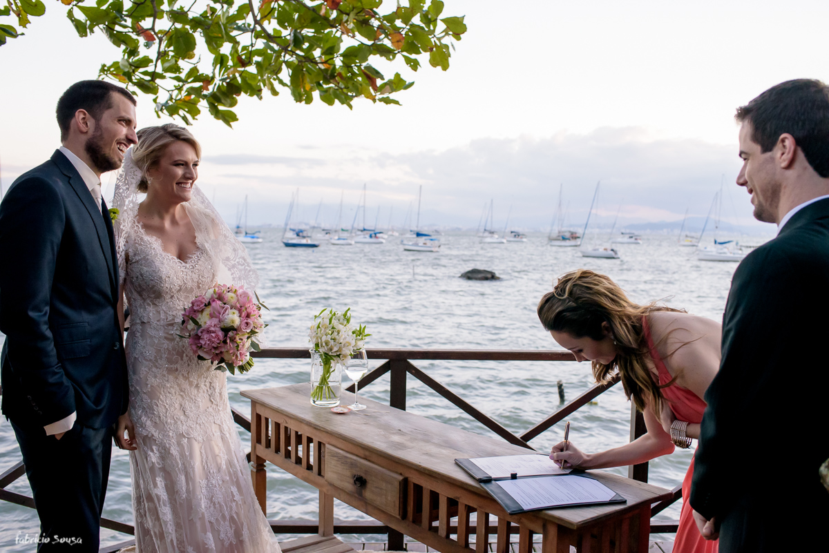 assinatura dos padrinhos com o mar da baía norte de Florianópolis ao fundo