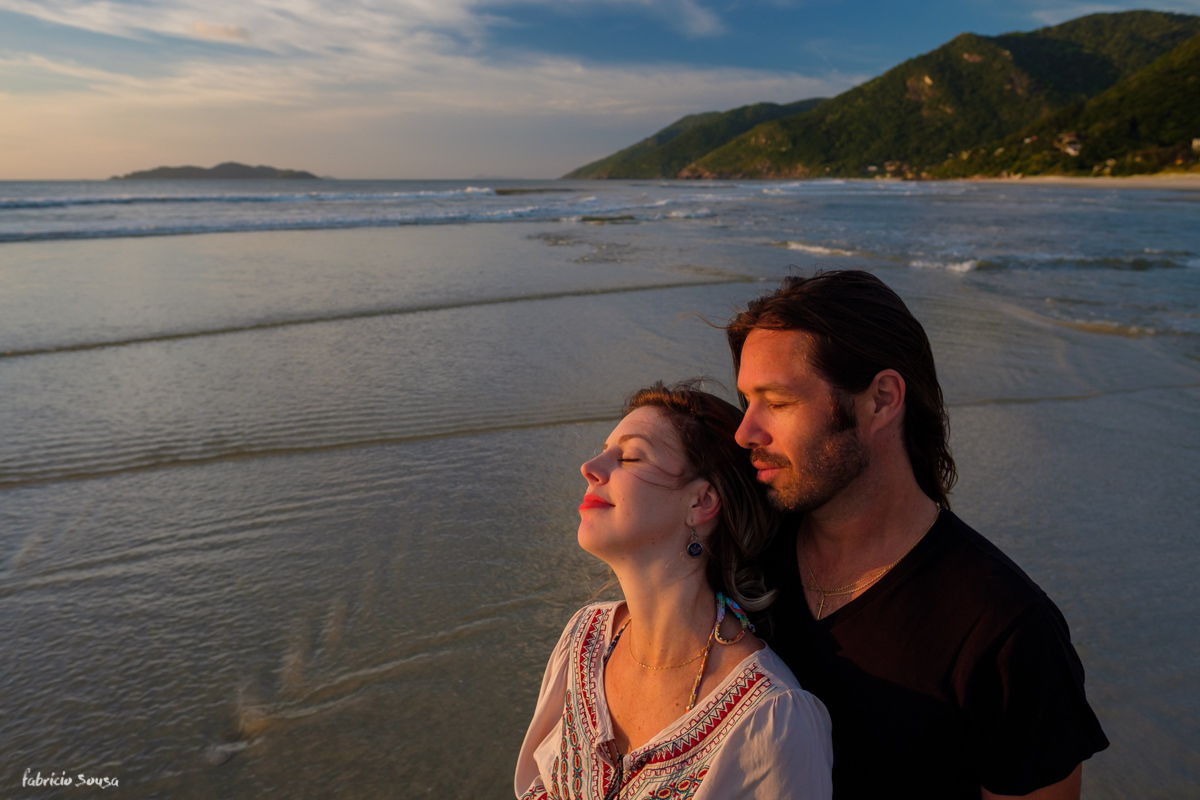 casal curtindo a brisa ao amanhecer na praia em sessão fotográfica de casamento