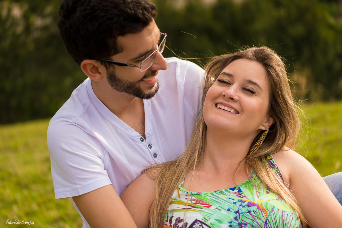 sorriso gostoso no aconchego do noivo durante ensaio fotográfico prewedding em Águas Mornas grande Floripa