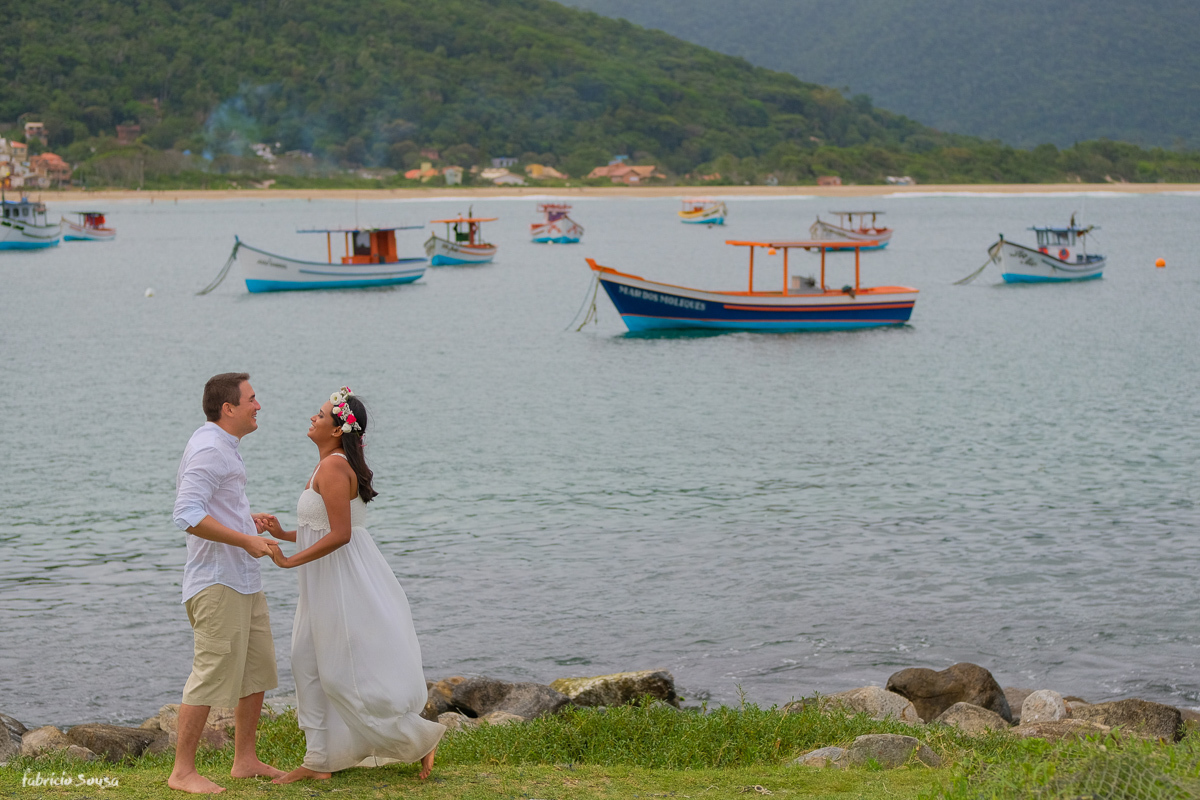 retrato do casal feliz logo após seu casamento e ao fundo o mar com barquinhos que levam a ilha do Campeche
