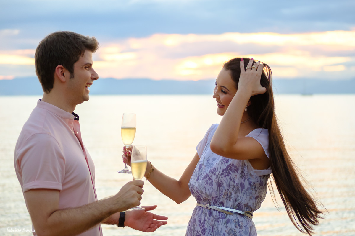 o primeiro brinde dos noivos no momento das fotos na beira do mar na praia de Santo Antonio