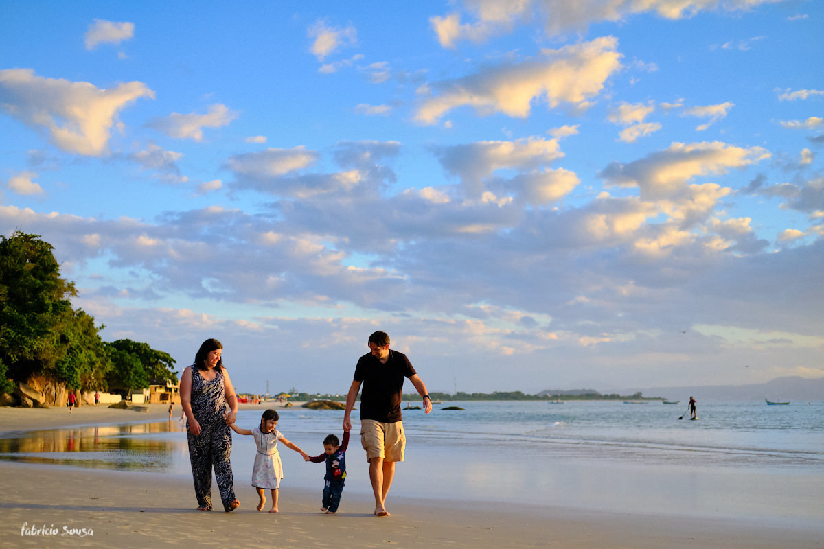 família toda caminhando junto na praia num belíssimo final de tarde de outono em Florianópolis