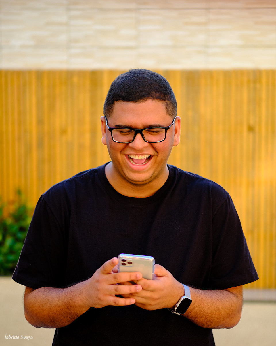 retrato corporativo descontraído do jovem Samuel Meneses com seu celular - material para anúncios publicitários para seu lançamento digital