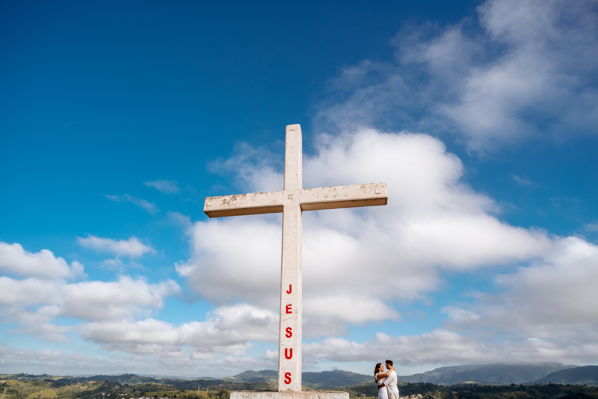 Ensaio pré-wedding romântico no campo, com casal trocando olhares apaixonados em meio à luz dourada da manhã