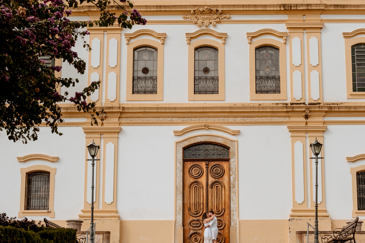 Noivos posam em frente à igreja histórica de Santana de Parnaíba, local significativo para o casal