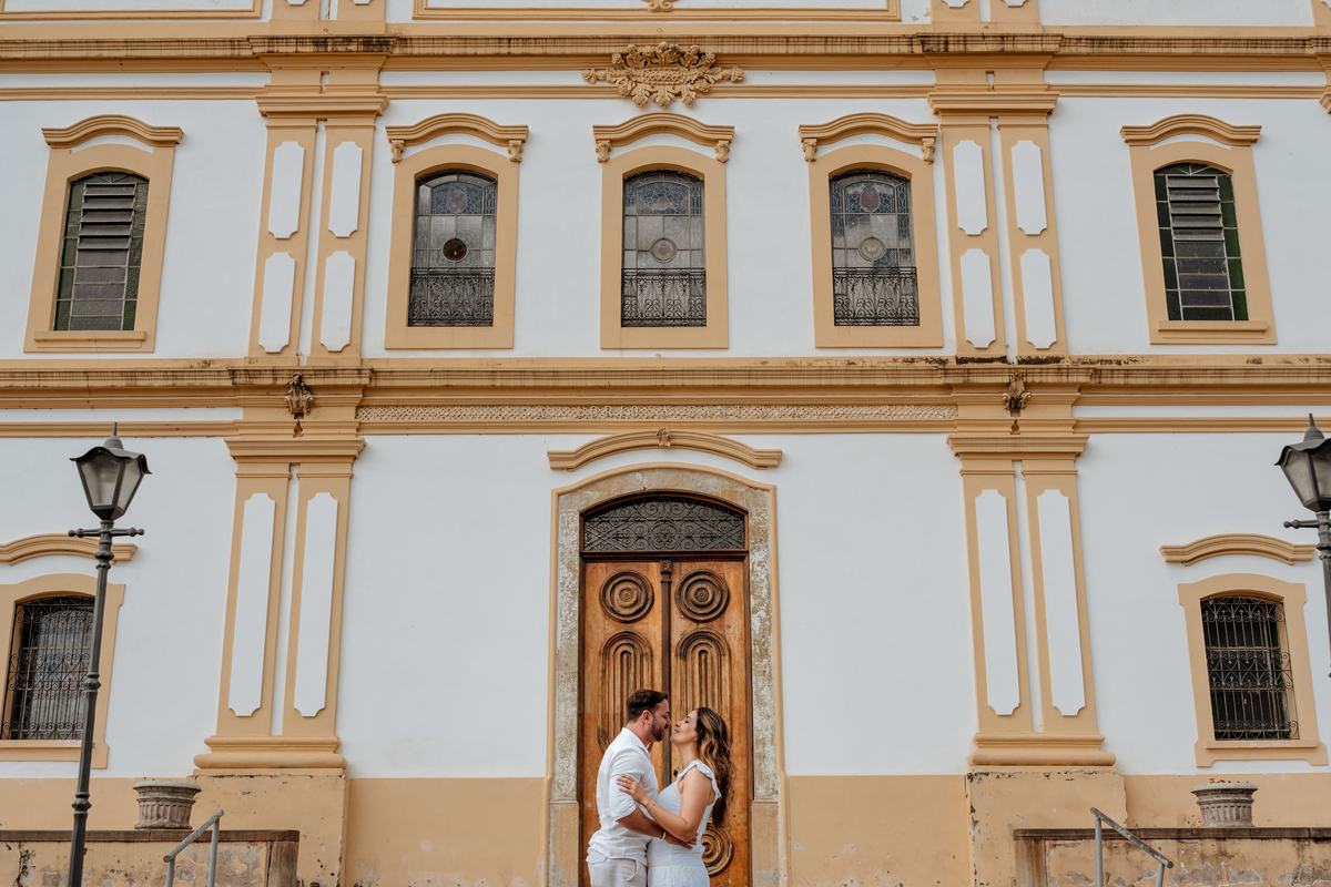 Noivos posam em frente à igreja histórica de Santana de Parnaíba, local significativo para o casal