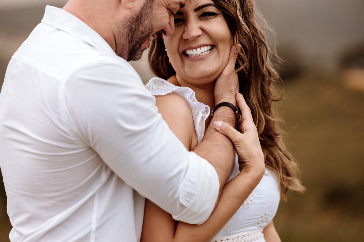 Casal em ensaio pré-wedding ao nascer do sol no Morro do Capuava, rodeado pela natureza e acompanhados por seus cachorros