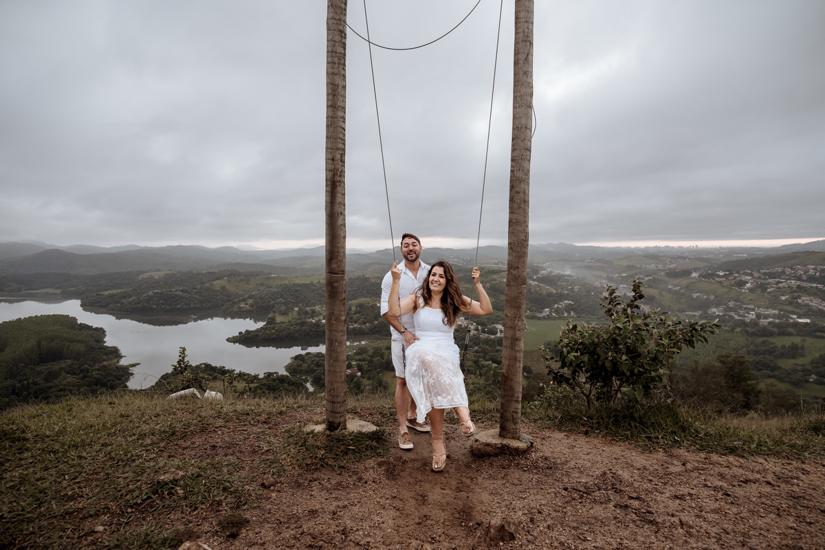 Casal em ensaio pré-wedding ao nascer do sol no Morro do Capuava, rodeado pela natureza e acompanhados por seus cachorros