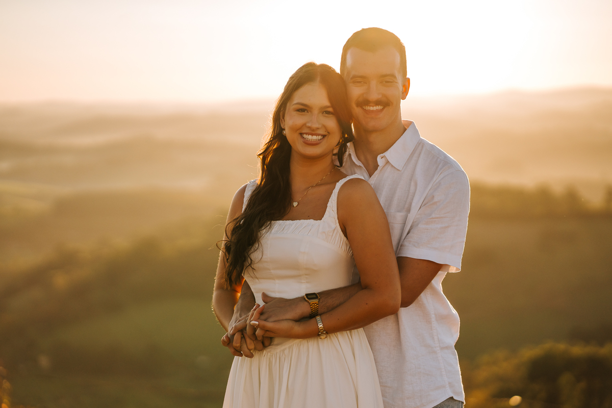 Ensaio pré-wedding com pôr do sol no alto de Pedra Bela-SP — casal trocando carinho com vista para as montanhas.