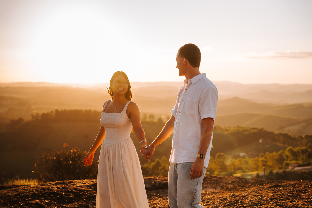 Luz dourada da golden hour realçando a conexão de Maria Eduarda e Pablo em Pedra Bela-SP
