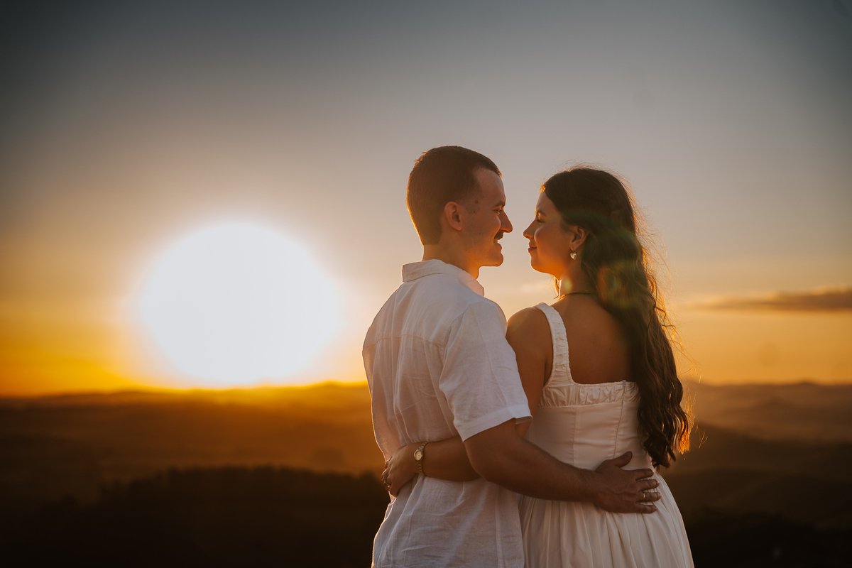 Luz dourada da golden hour realçando a conexão de Maria Eduarda e Pablo em Pedra Bela-SP

