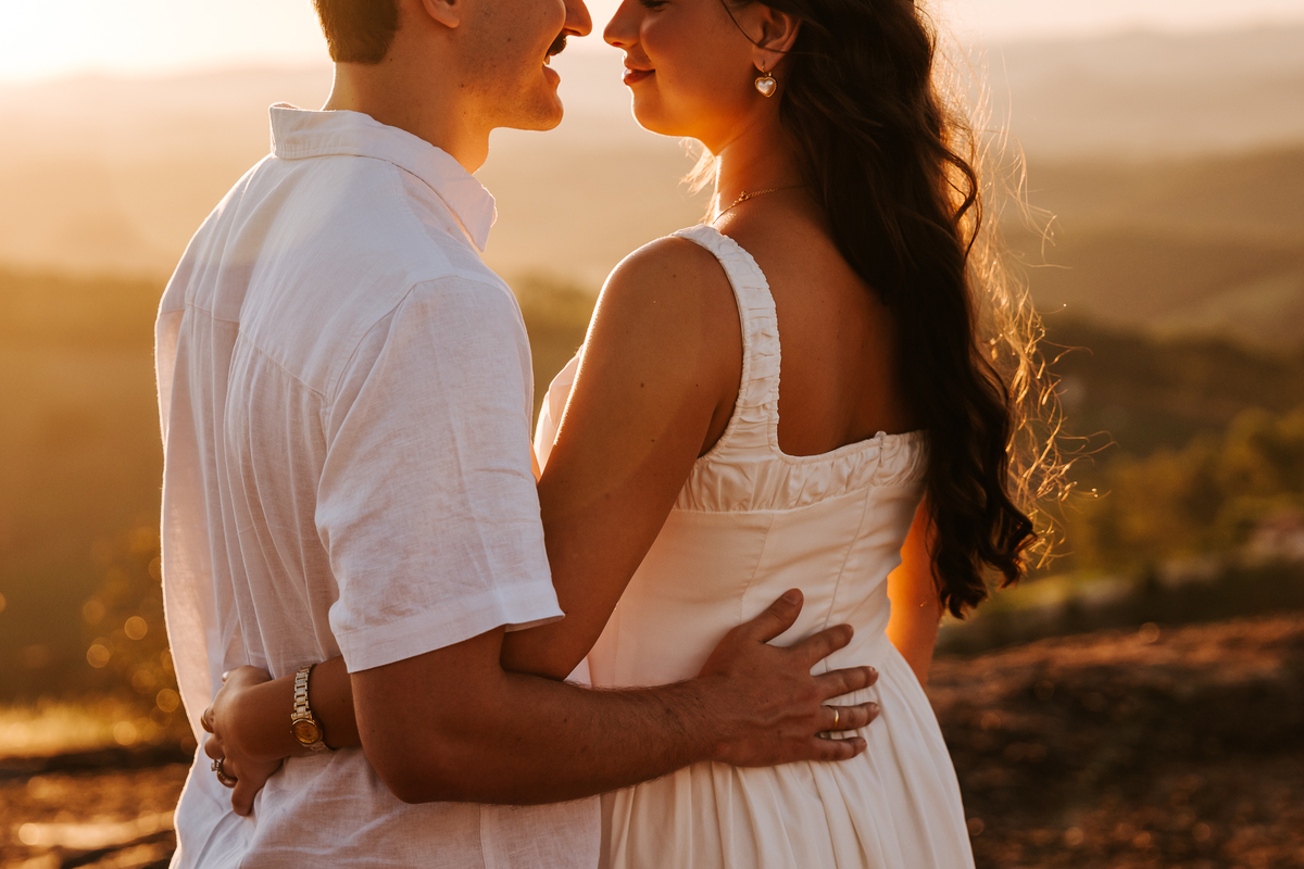 Luz dourada da golden hour realçando a conexão de Maria Eduarda e Pablo em Pedra Bela-SP
