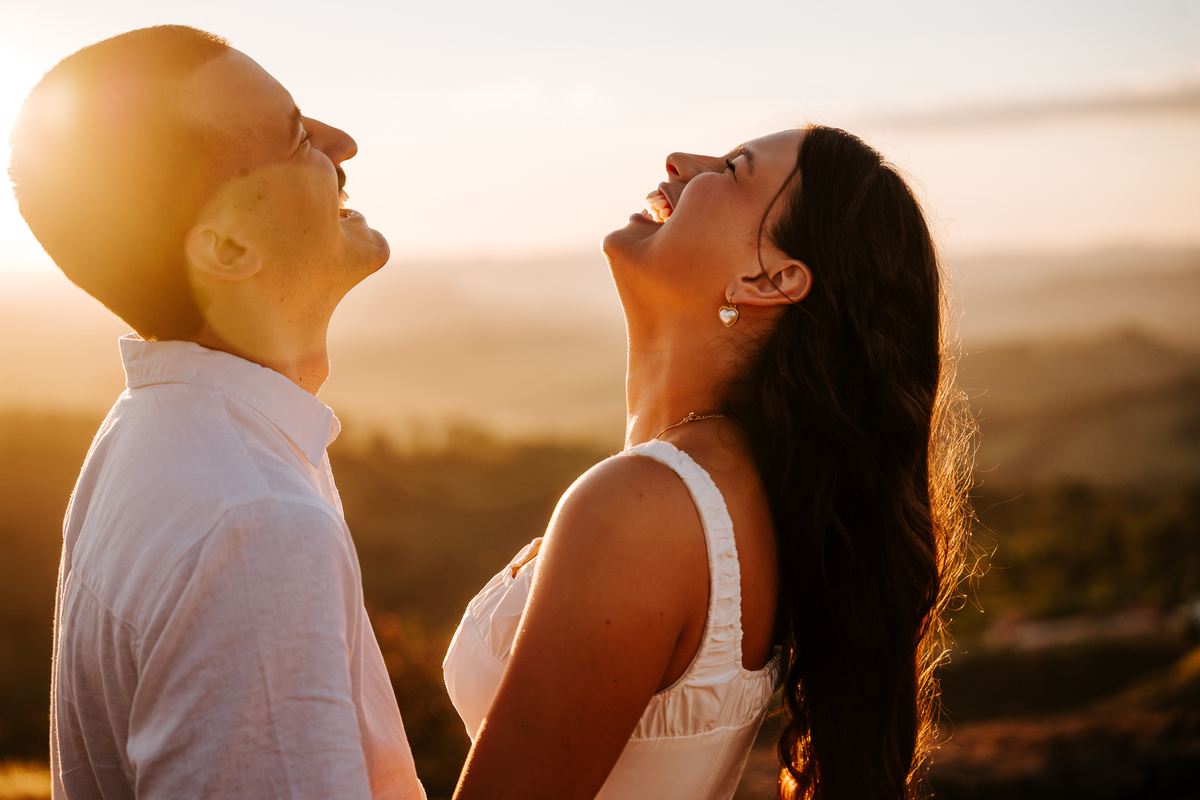 Luz dourada da golden hour realçando a conexão de Maria Eduarda e Pablo em Pedra Bela-SP
