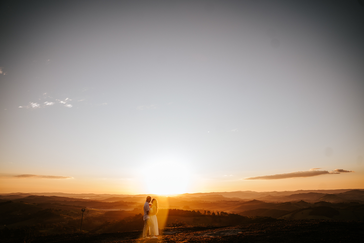 Luz dourada da golden hour realçando a conexão de Maria Eduarda e Pablo em Pedra Bela-SP
