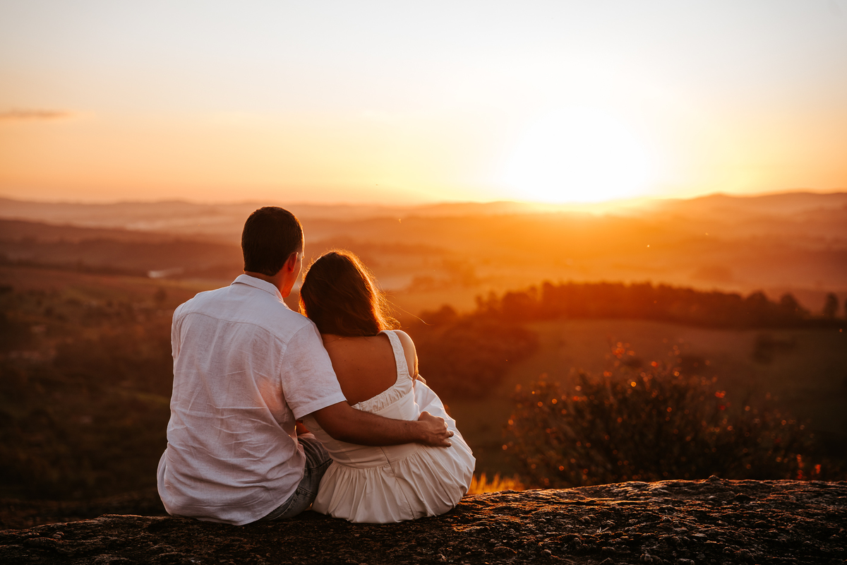 Luz dourada da golden hour realçando a conexão de Maria Eduarda e Pablo em Pedra Bela-SP
