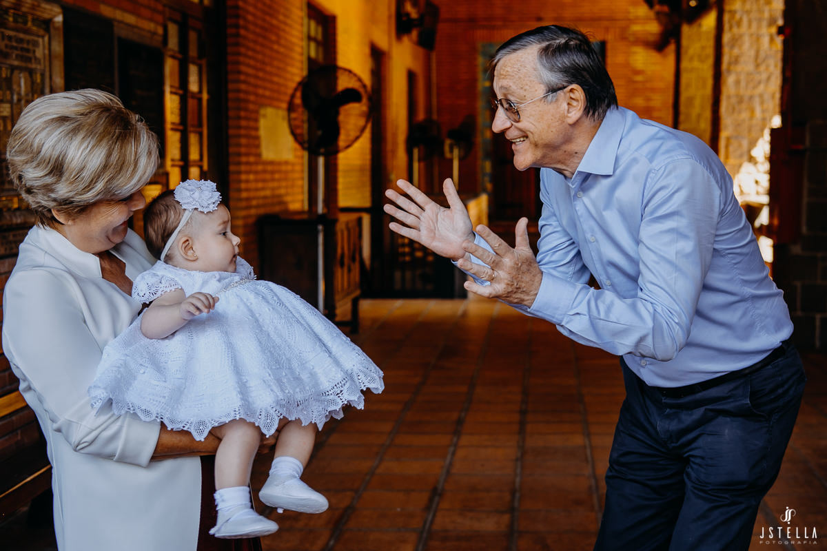 Vovô brincando com netinha no batizado