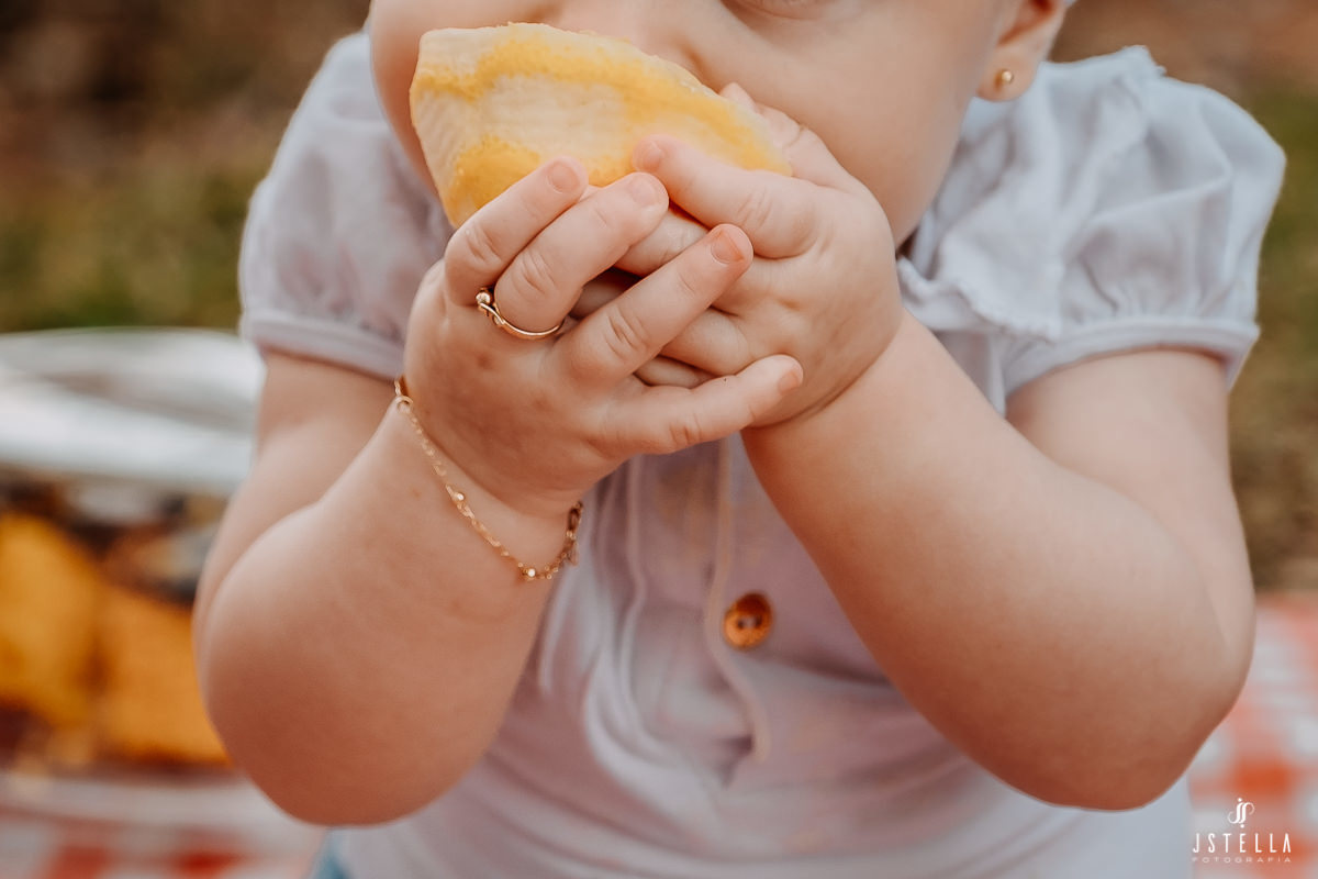 bebê segurando laranja
