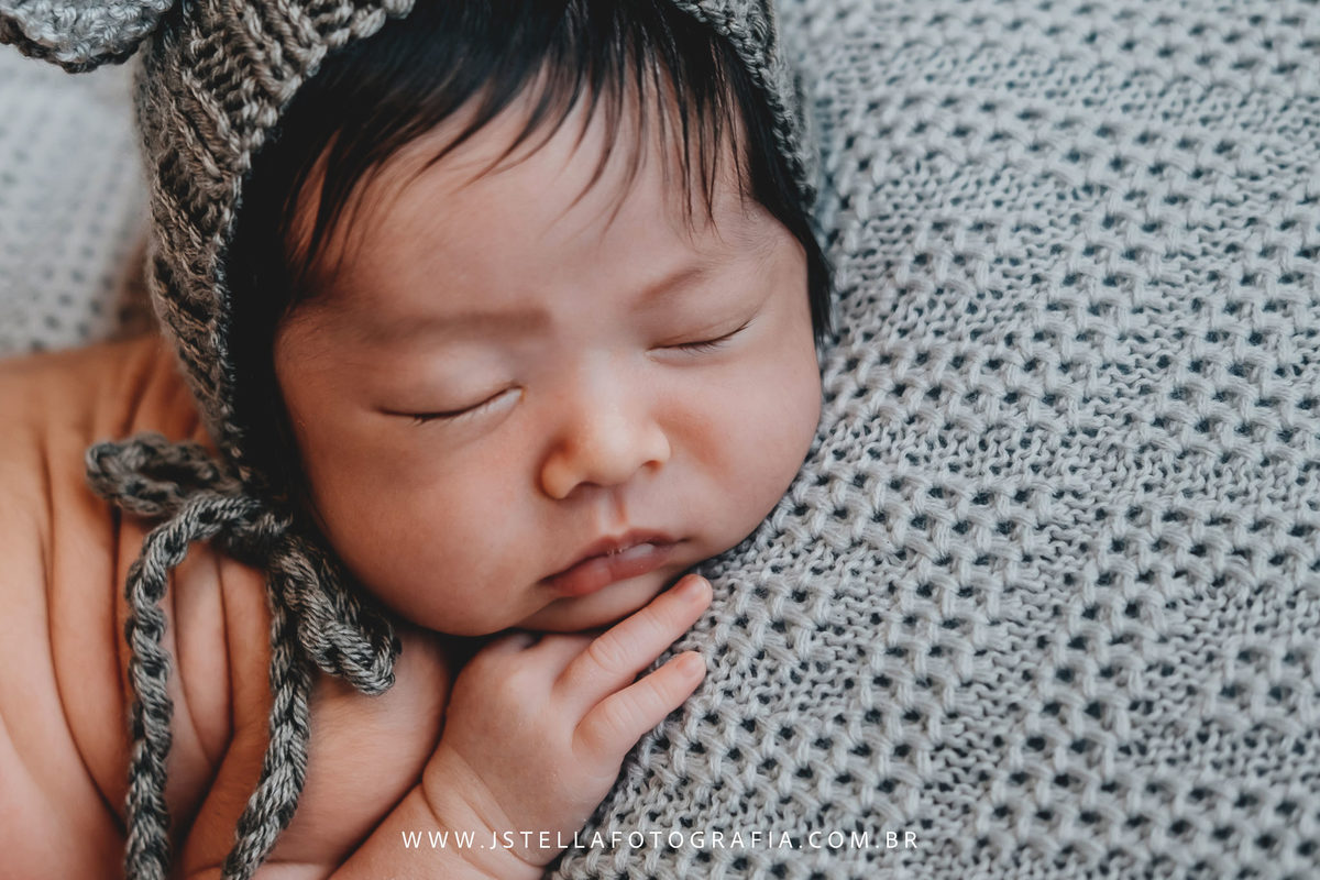 recém nascido com toquinha de orelhas