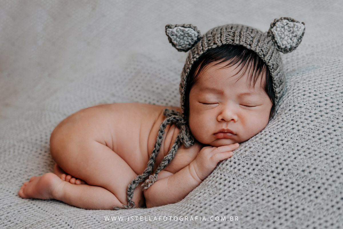 recém nascido com toquinha de orelhas