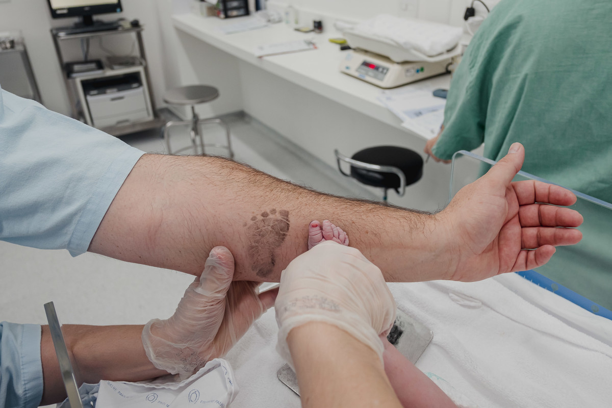 marca do pé no braço do pai