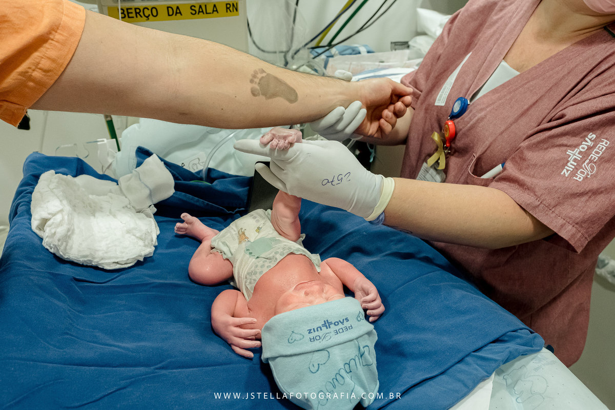 pezinho do recém nascido no braço do pai